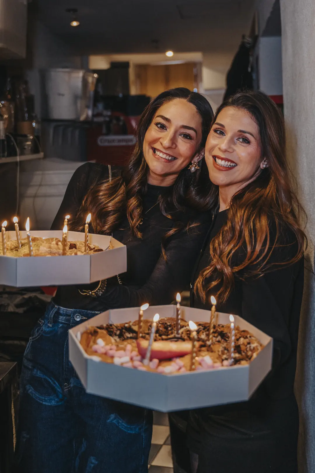 Dos clientas con la tarta de cumpleaños y las velas encendidas en La Tremenda